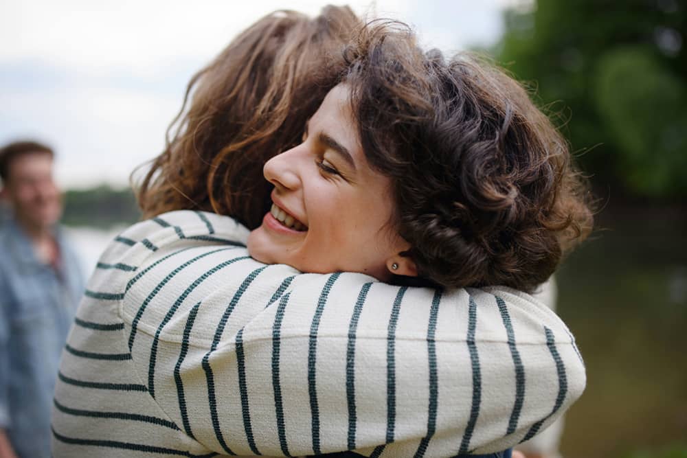 Two friends embracing each other in a supportive way